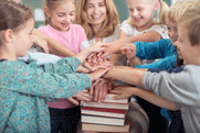 Teacher and students stacking their hands